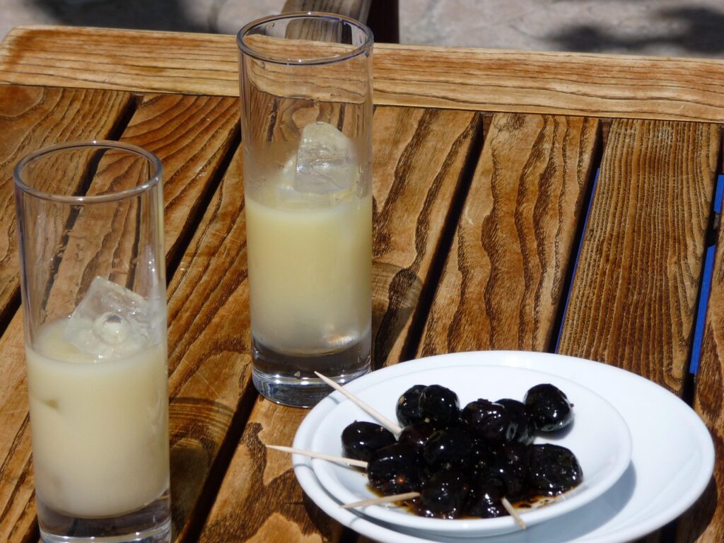 Images décrivant une façon de déguster le pastis Paul : Olives et pastis en apéro sur la table